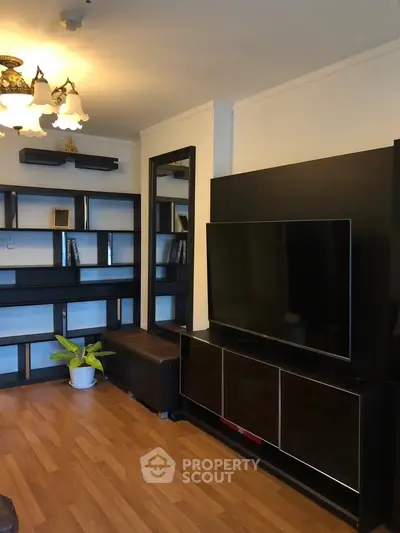 Spacious living room with modern TV setup and elegant shelving