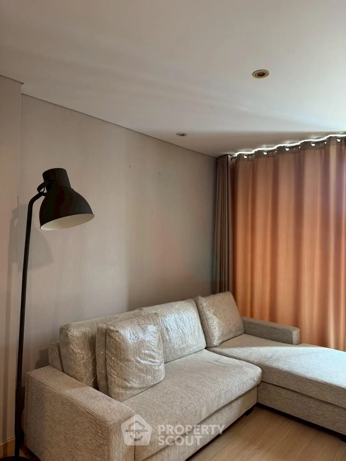 Cozy living room with modern sectional sofa and floor lamp, perfect for relaxation.
