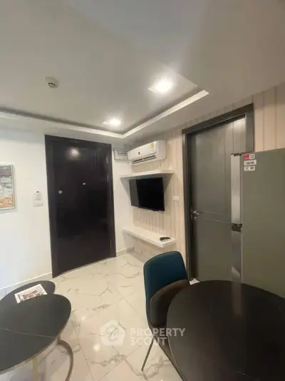 Modern apartment interior with sleek design, featuring a wall-mounted TV and stylish furniture.