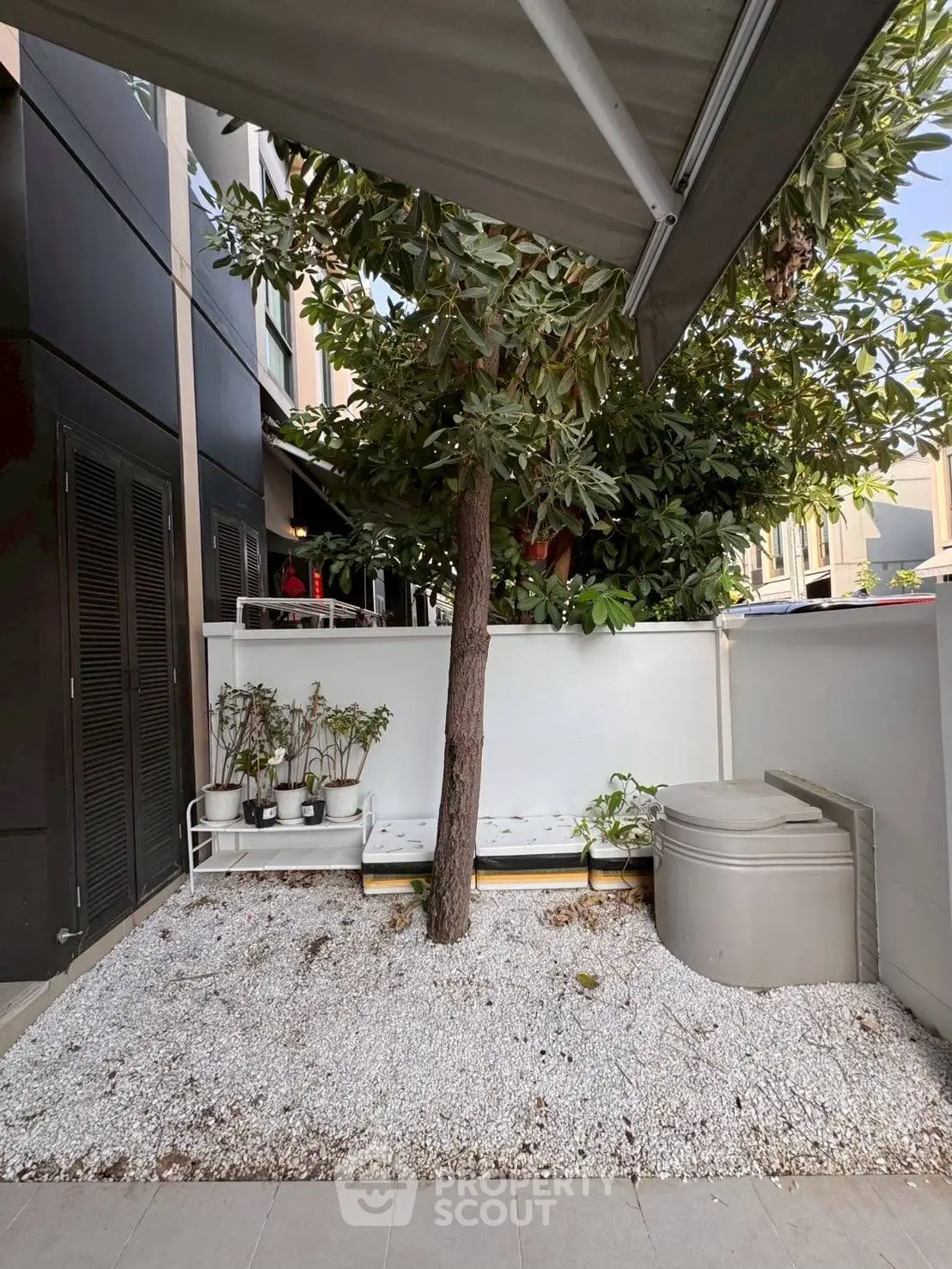 Charming outdoor garden space with tree and modern design elements in a residential setting.