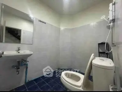 Spacious bathroom with modern fixtures and blue tile flooring.