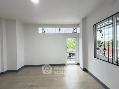 Spacious and bright living room with large windows and modern flooring, perfect for natural light lovers.