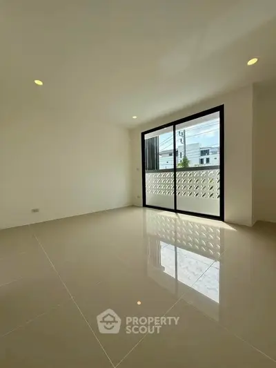 Spacious modern living room with large windows and glossy tiled floors