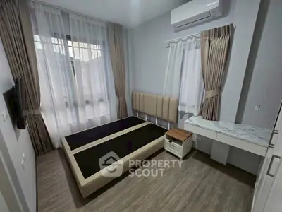 Modern bedroom with minimalist design, featuring a bed frame, air conditioning, and elegant curtains.
