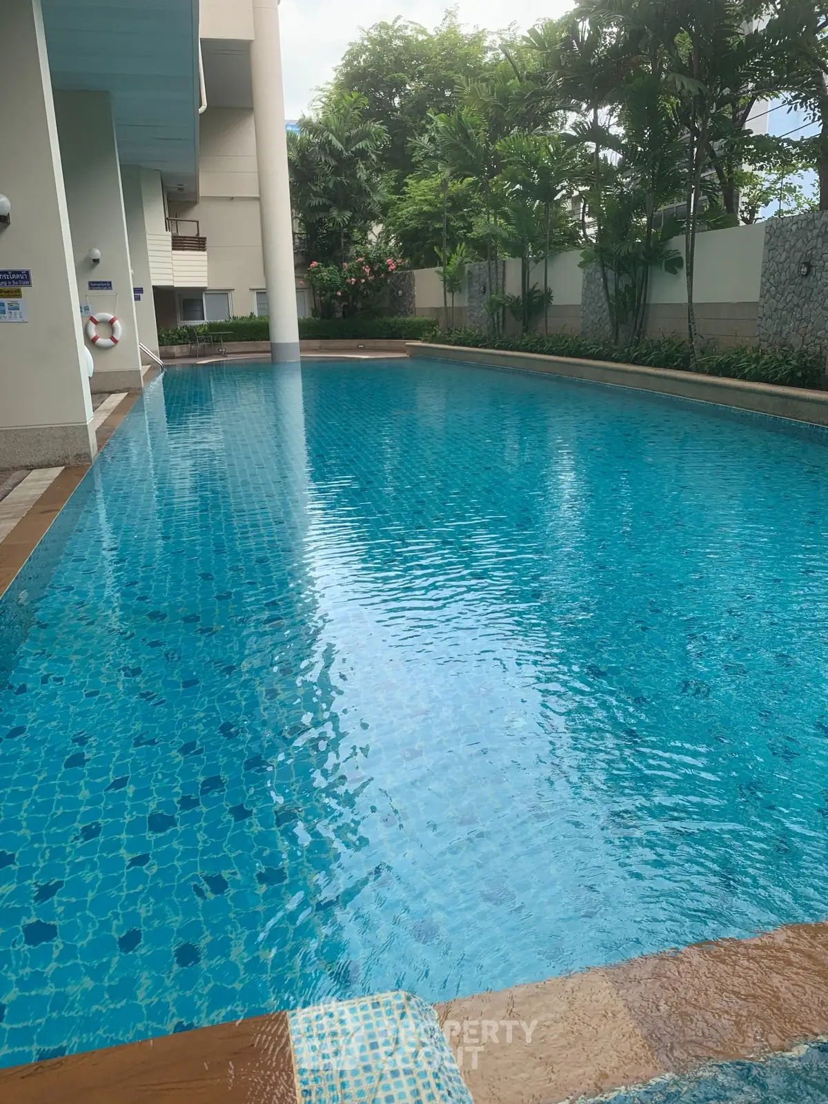 Luxurious residential pool with serene surroundings and lush greenery.