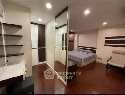 Spacious modern bedroom with wooden flooring and built-in wardrobe