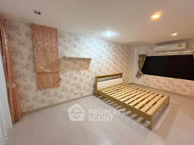 Spacious bedroom with elegant wallpaper and wooden bed frame, featuring modern lighting and air conditioning.