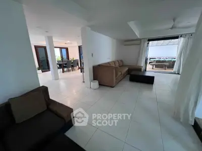 Spacious open-plan living room with modern furniture and large windows for natural light.