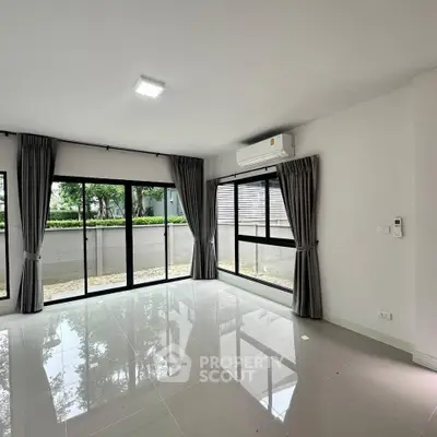Spacious modern living room with large windows and air conditioning, offering a bright and airy atmosphere.