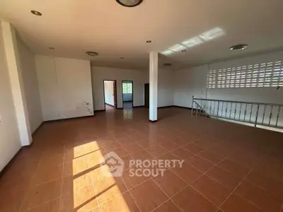 Spacious open-plan living area with tiled flooring and ample natural light.