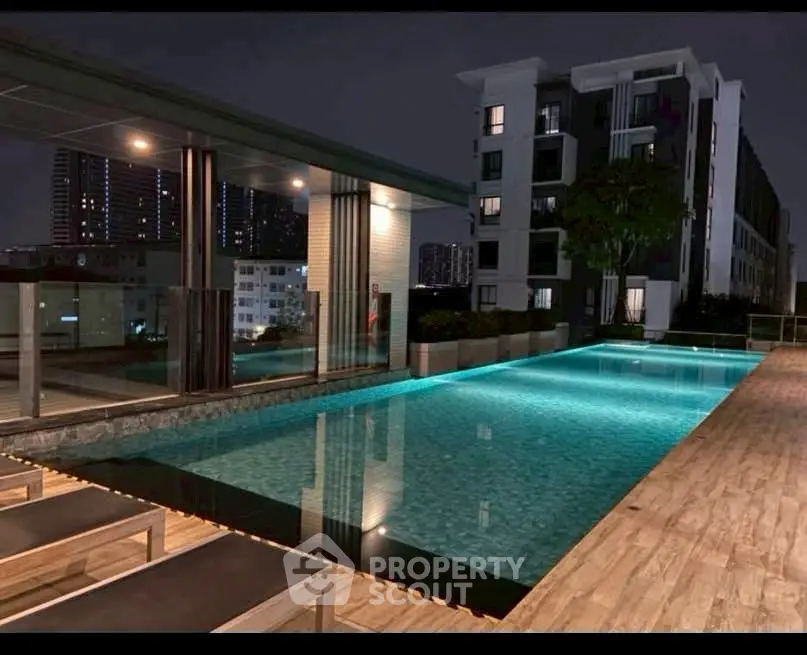 Luxurious rooftop pool with stunning night city views in modern apartment complex.