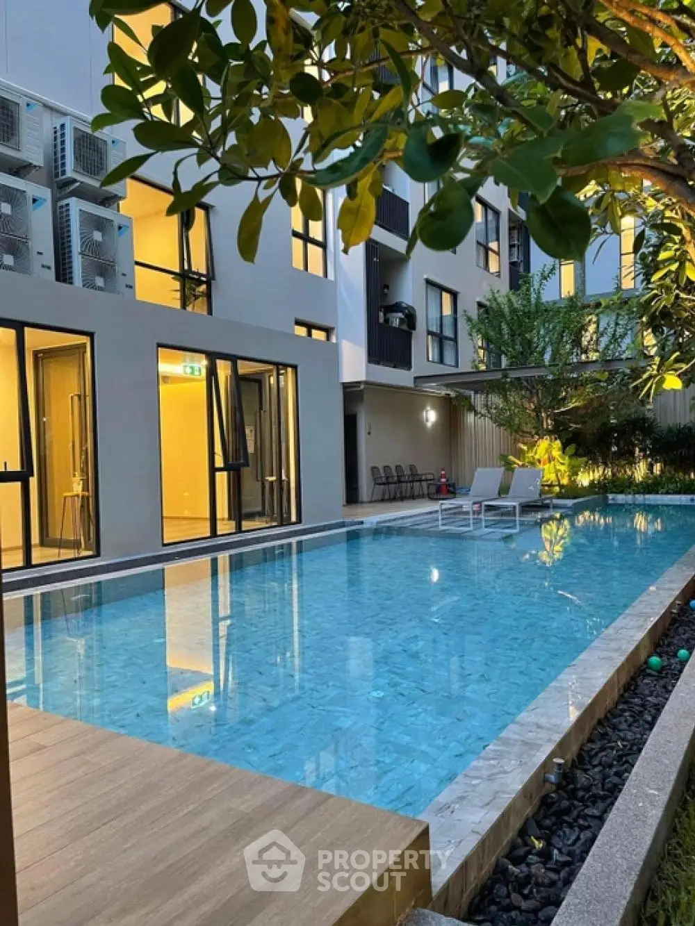 Modern apartment building with inviting pool and lush greenery