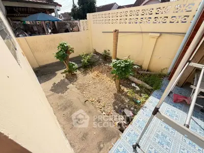 Charming small garden area with tiled steps and decorative wall, perfect for outdoor relaxation.
