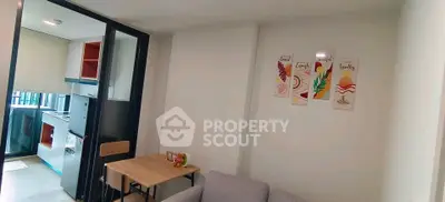 Modern living room with compact kitchen and stylish decor in a cozy apartment.