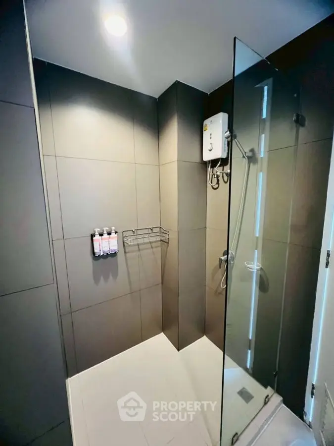Modern bathroom with sleek glass shower and dark tile design