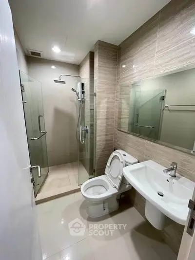 Modern bathroom with glass shower and sleek fixtures in a contemporary apartment.