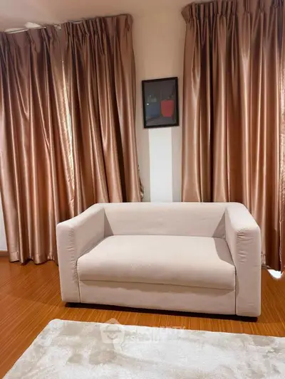 Cozy living room with elegant curtains and a modern beige sofa, perfect for relaxation.