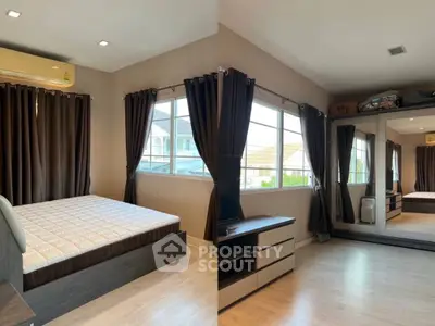 Spacious bedroom with large windows and modern furnishings, perfect for comfortable living.
