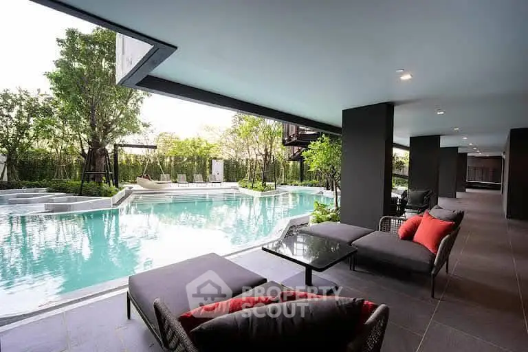 Luxurious poolside lounge area with modern seating and lush greenery