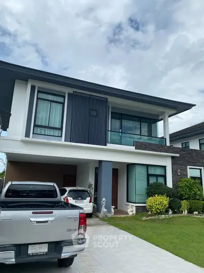 Modern two-story house with landscaped front yard and driveway parking.