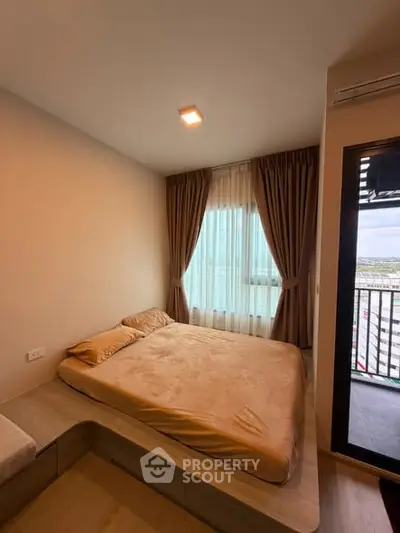 Cozy bedroom with large window and balcony access in modern apartment