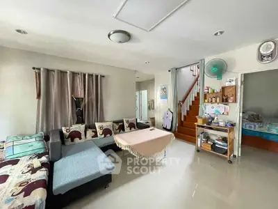 Spacious living room with modern decor and staircase leading to upper floor
