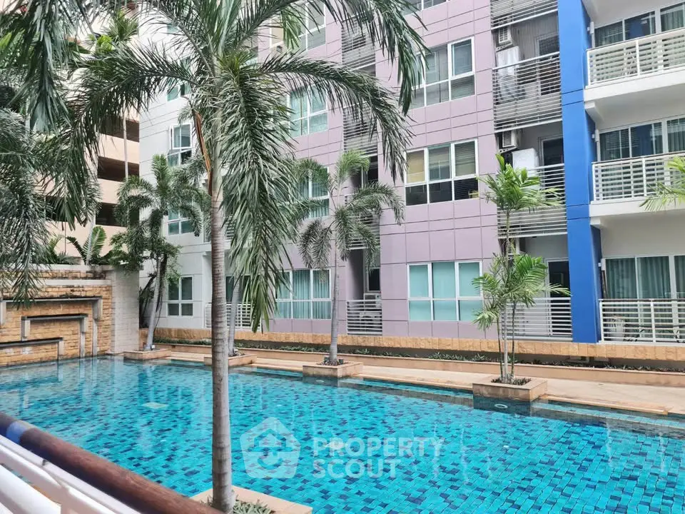 Modern apartment building with a stunning outdoor pool and lush palm trees.