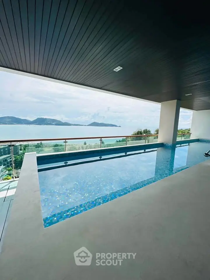 Luxurious rooftop pool with stunning ocean view in modern real estate property.