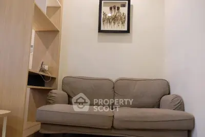 Cozy living room with a comfortable sofa and stylish wall art, perfect for relaxation.