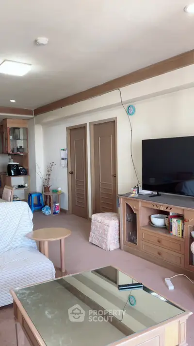 Cozy living room with modern TV setup and open kitchen layout