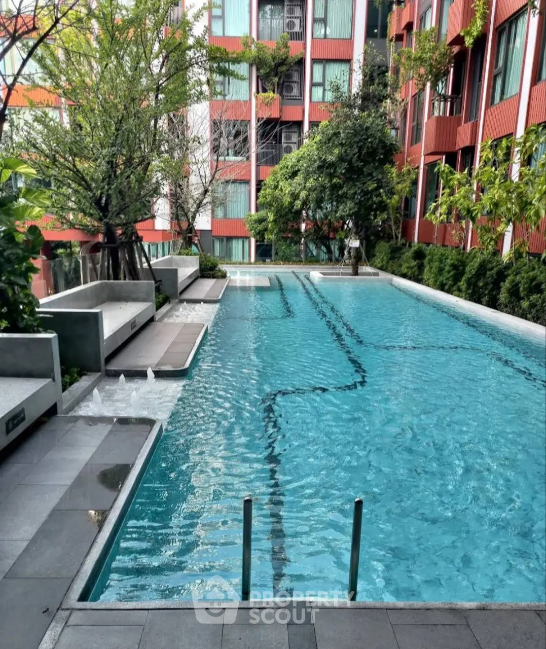 Luxurious residential pool with modern design and lush greenery, perfect for relaxation and leisure.