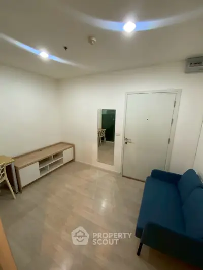 Cozy minimalist living room with blue sofa and wooden flooring