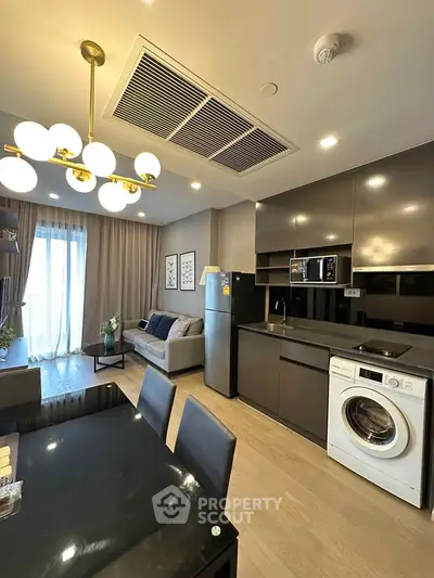 Modern open-layout kitchen with sleek appliances and cozy living area, perfect for urban living.