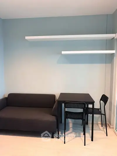 Modern minimalist living room with sleek black furniture and floating shelves.