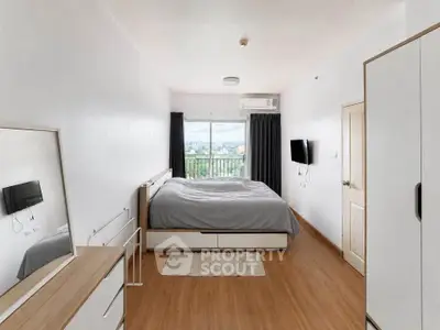 Spacious bedroom with modern decor and large window offering scenic views.