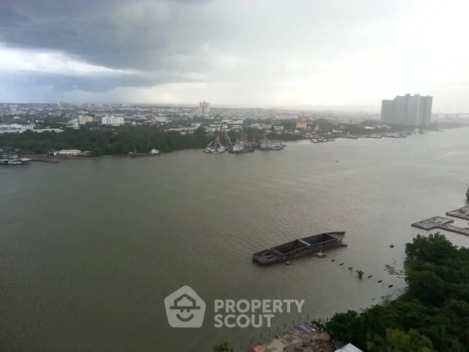 Stunning river view from high-rise apartment overlooking city skyline and lush greenery.