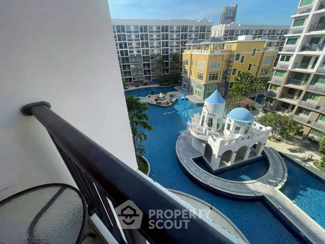 Stunning view from balcony overlooking luxurious pool and modern apartment complex.