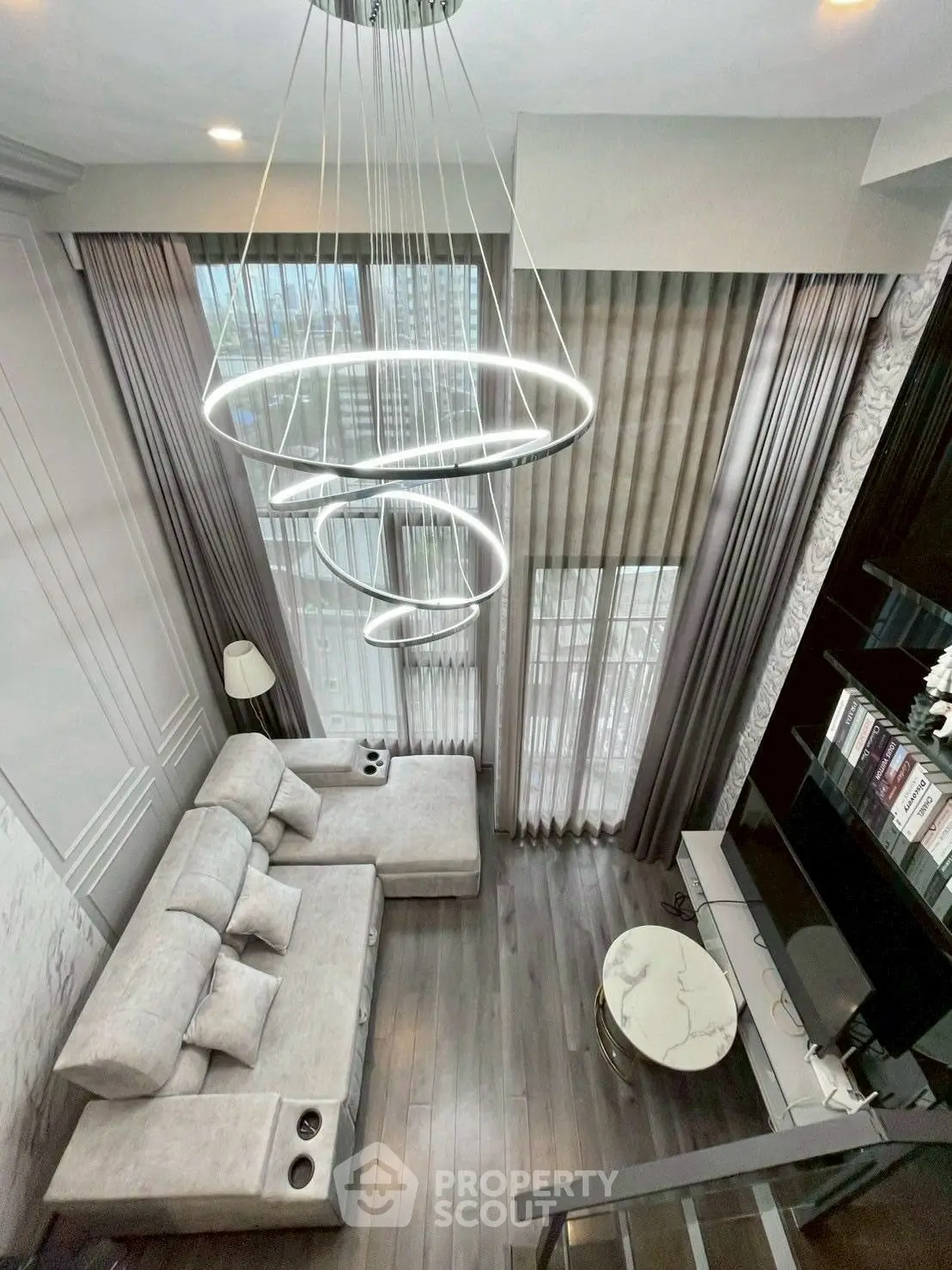 Luxurious modern living room with high ceiling and elegant chandelier