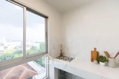 Bright kitchen with marble countertops and city view from window