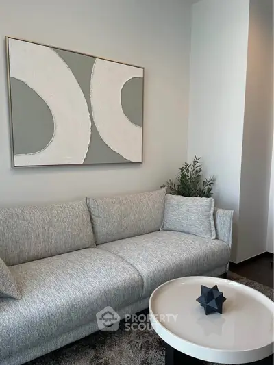 Modern living room with stylish gray sofa and abstract wall art, perfect for contemporary urban living.