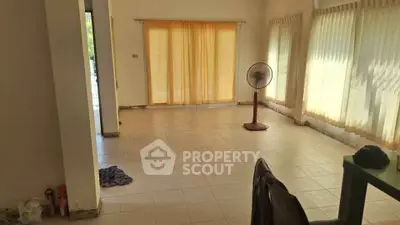 Spacious living room with large windows and natural light, ideal for cozy gatherings.