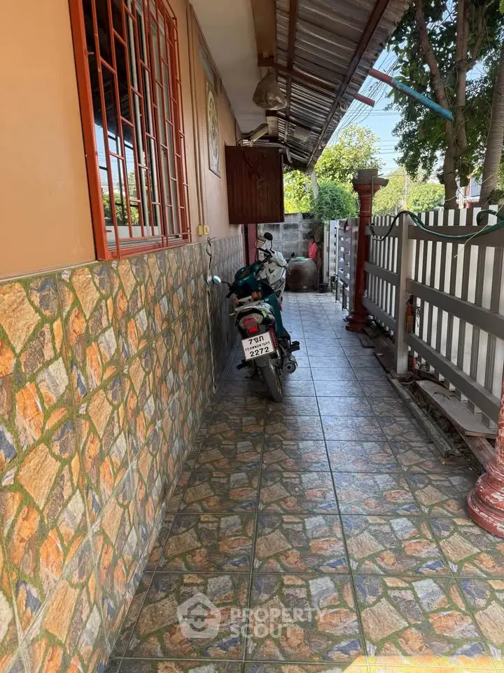 Charming exterior corridor with tiled flooring and decorative wall, perfect for a cozy outdoor space.