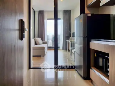 Modern apartment interior with open kitchen and living room, featuring sleek appliances and a cozy balcony view.