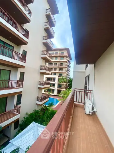 Spacious balcony with pool view in modern apartment complex