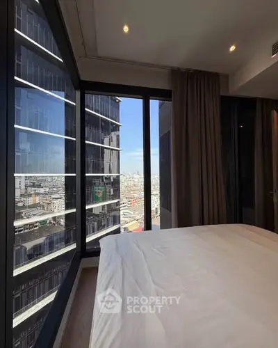 Luxurious bedroom with stunning city view from floor-to-ceiling windows in modern high-rise apartment.