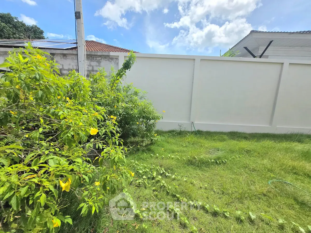 Lush green garden with vibrant yellow flowers and clear blue sky