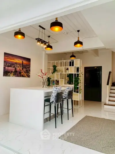 Modern kitchen with sleek white island and stylish lighting in open layout