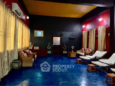 Spacious living room with vibrant blue floor and cozy seating area