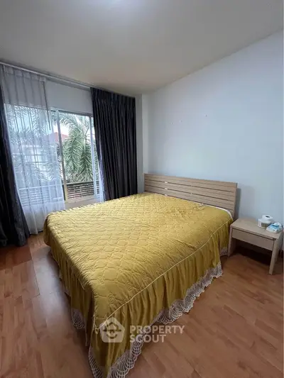 Spacious bedroom with large window and elegant decor