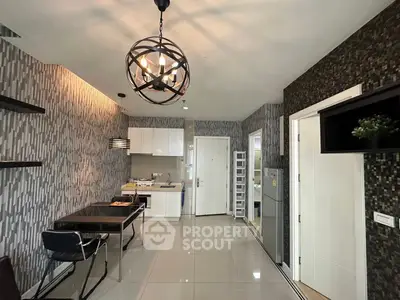 Modern open-layout kitchen and dining area with stylish lighting and sleek design.